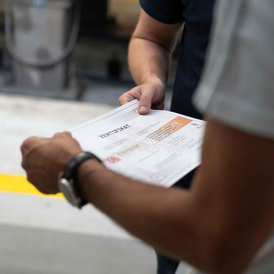Two people hold a certificate in their hand